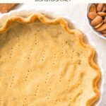 Top down view of low carb pie crust with a bowl of almonds