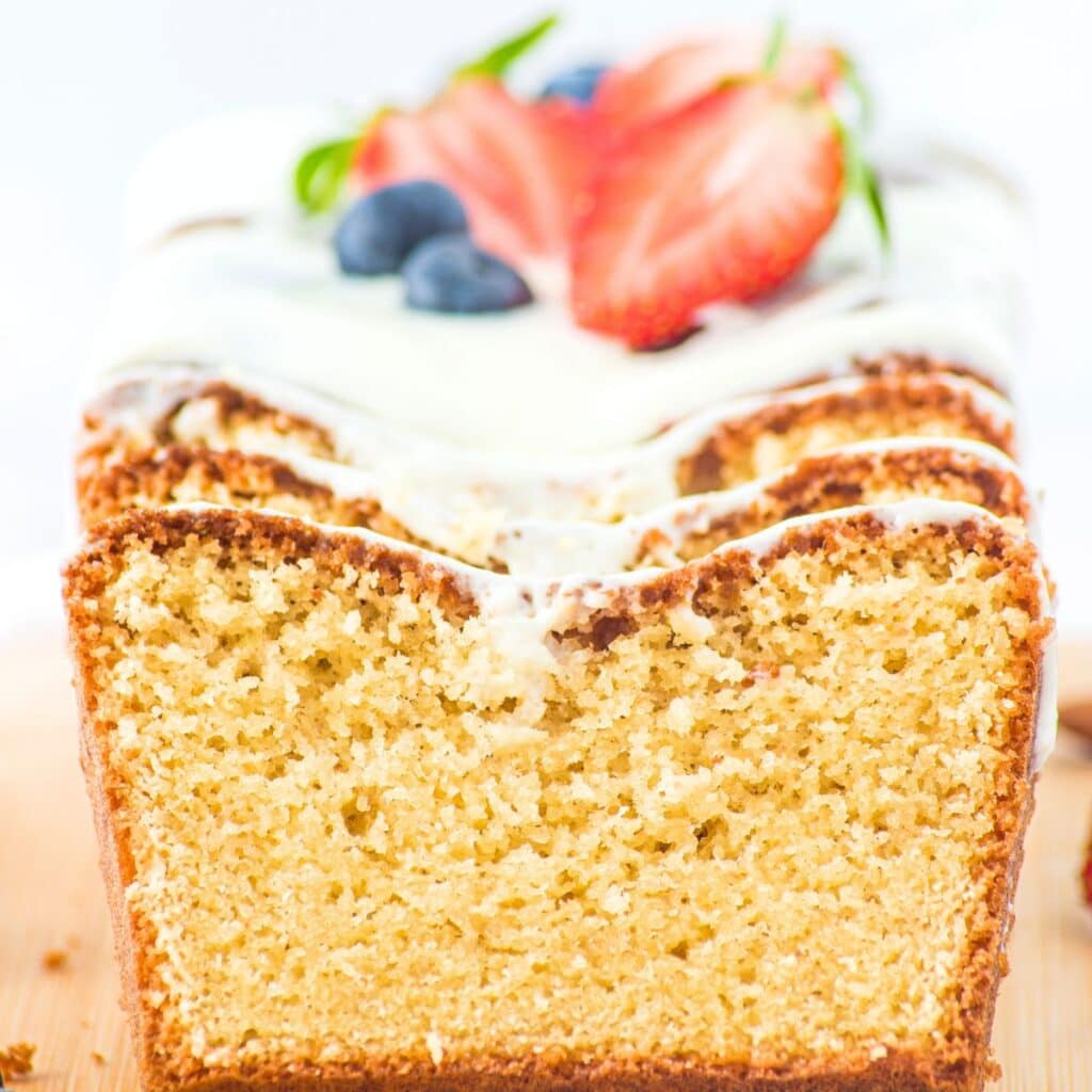 Up close view of the texture of half-sliced loaf of almond flour pound cake.