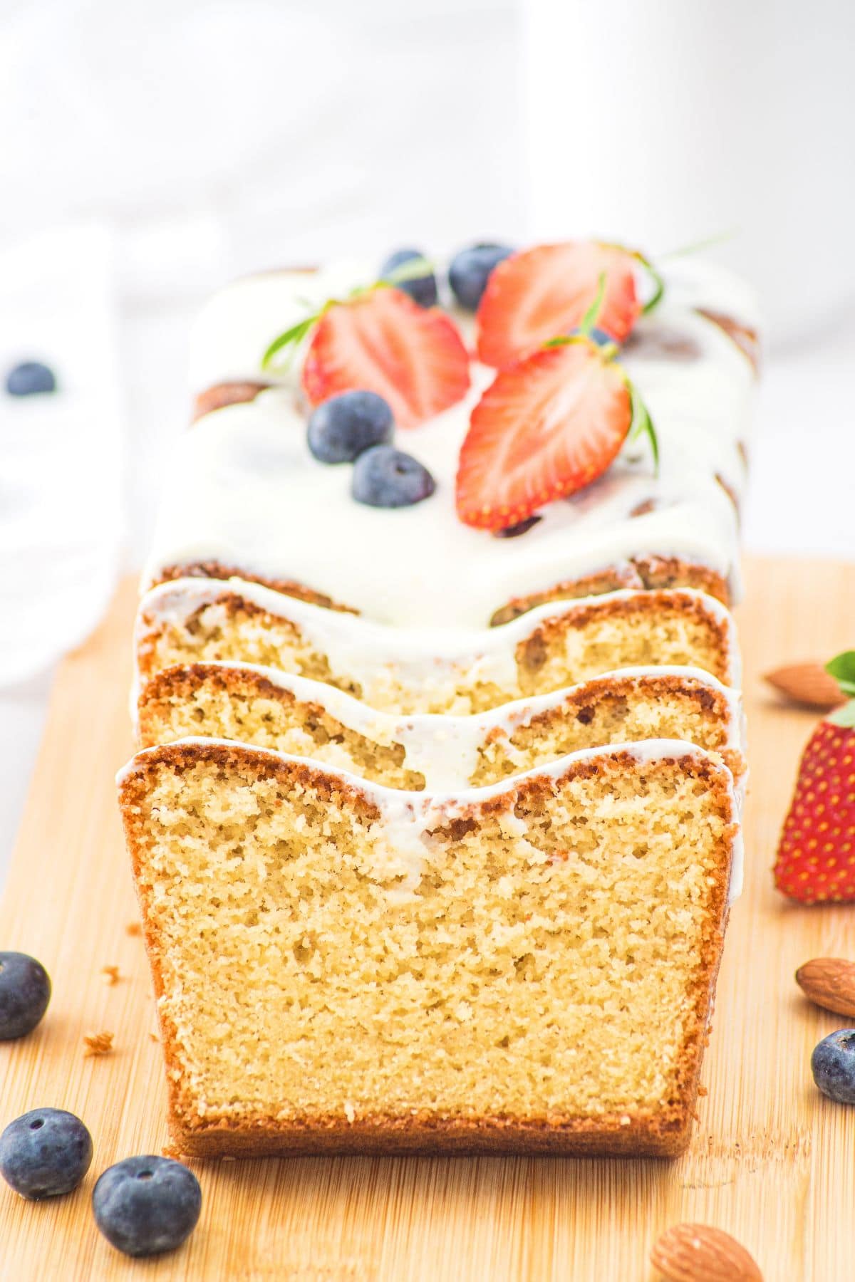 Up close view of sliced loaf of almond flour pound cake on wooden board
