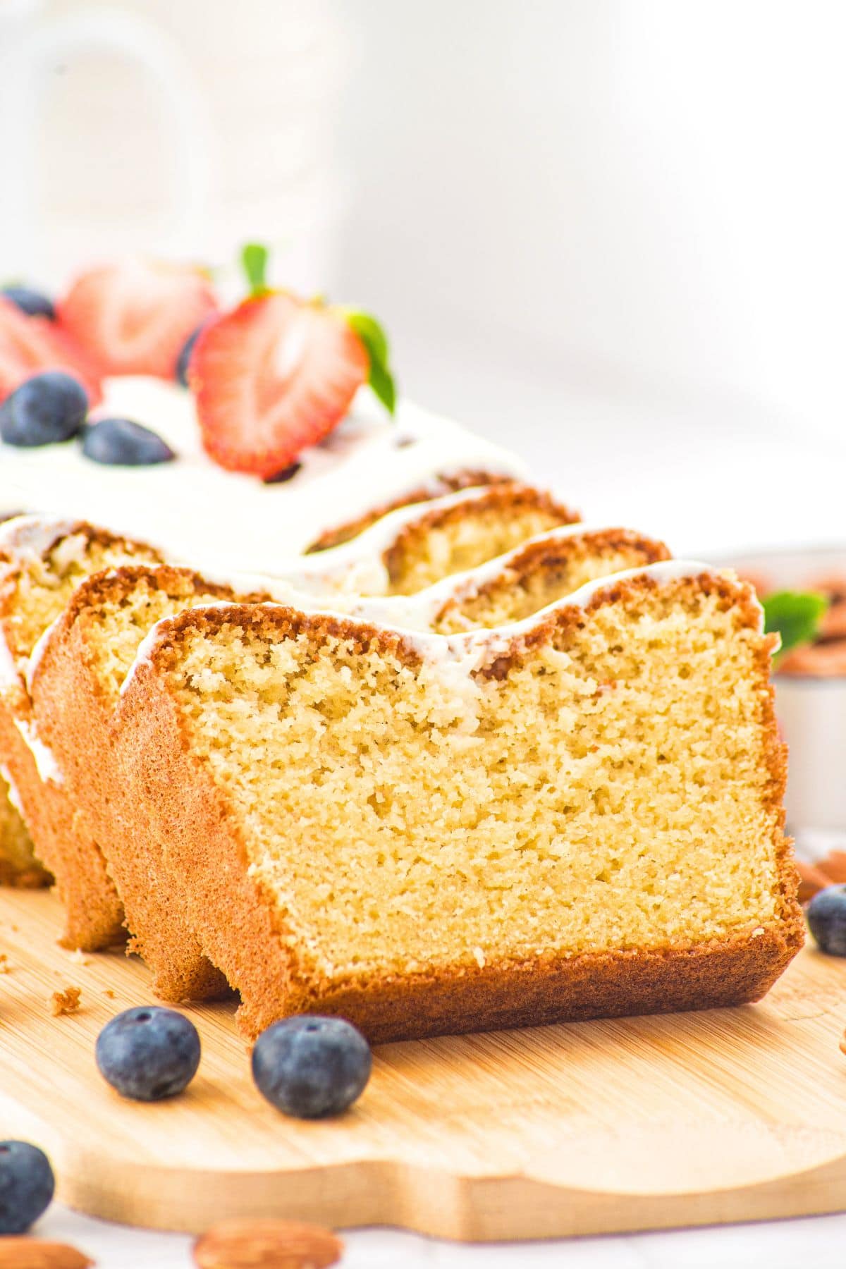 Slices of gluten-free almond flour pound cake on wooden board.