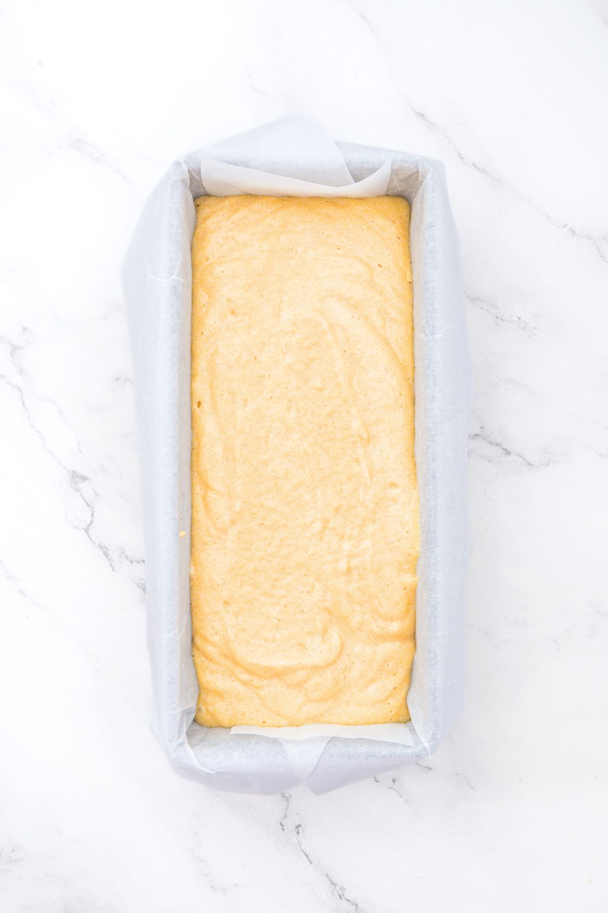 Almond flour pound cake batter in parchment-lined loaf pan.