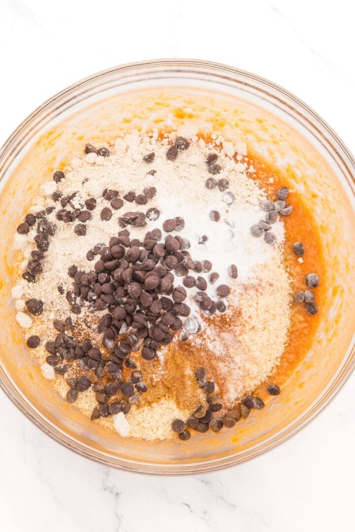 Gladd bowl with orange mixture topped with almond flour, spices and chocolate chips.