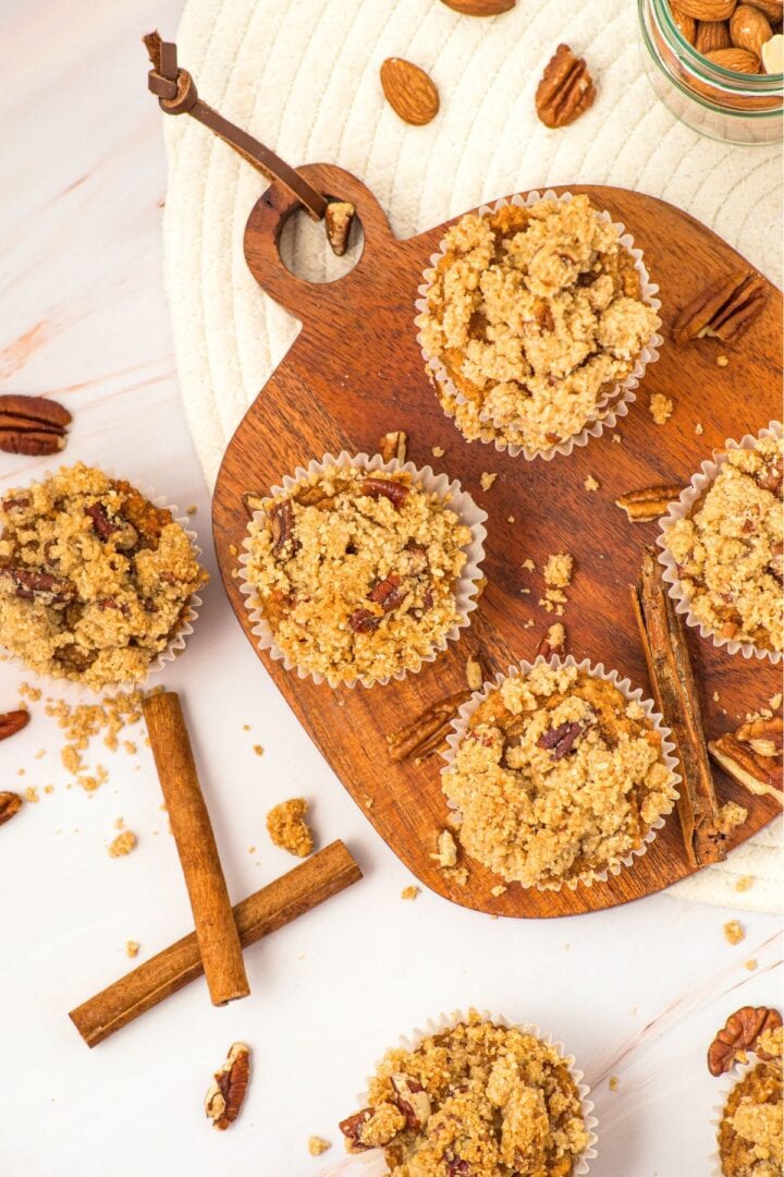 Top down view of pumpkin almond flour muffins on wooden board.