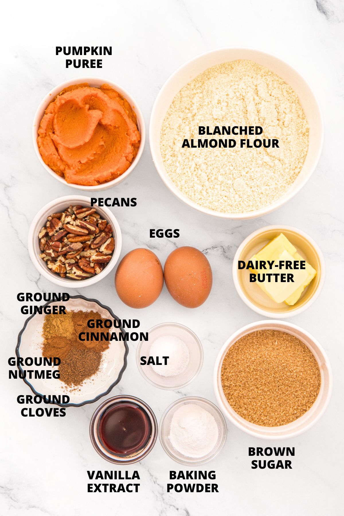 Ingredients for almond flour pumpkin muffins recipe laid out on marble board.