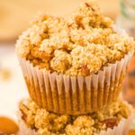A stack of pumpkin almond flour muffins topped with streusel