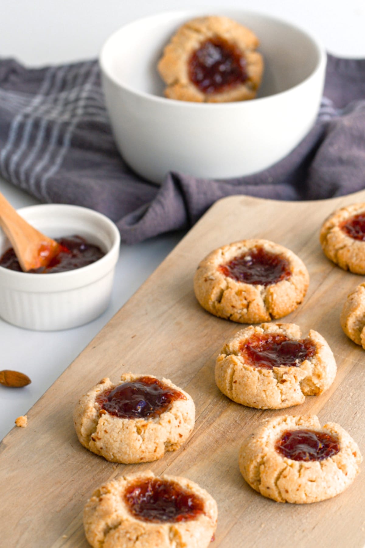Almond flour thumbprint cookies on wooden board.