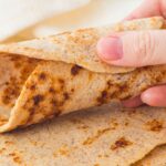 Holding a rolled tortilla wrap