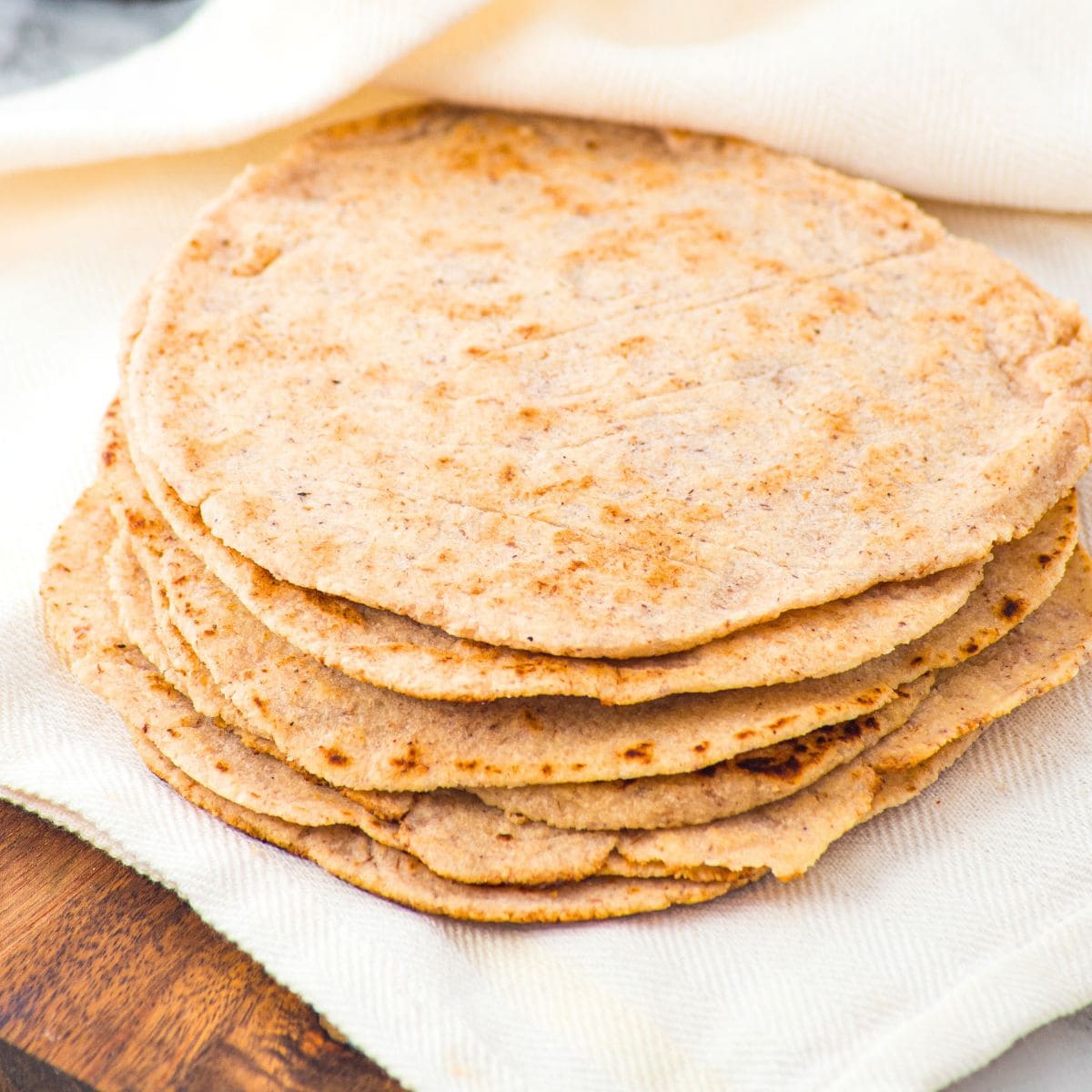 A stack of almond flour tortillas on kitchen towel
