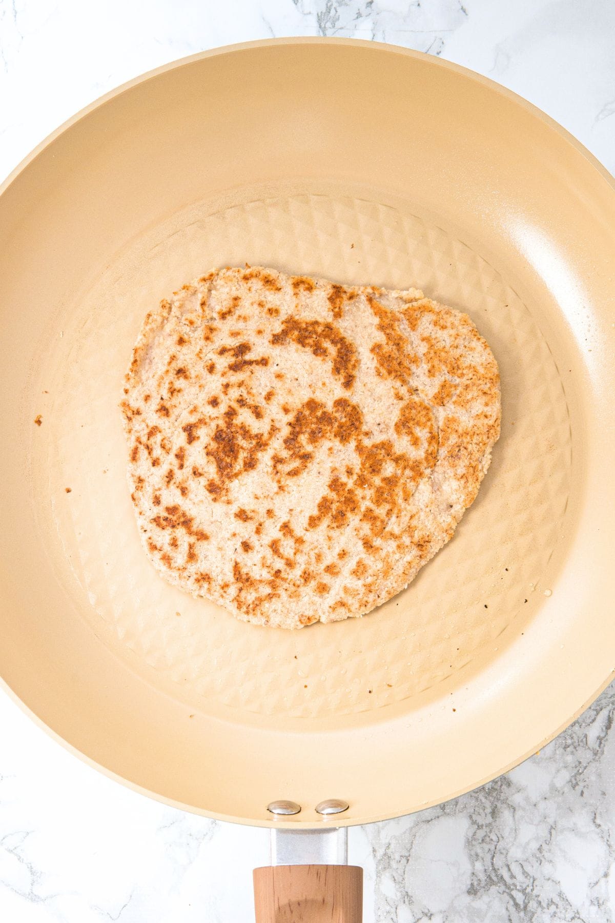 Cooking almond flour tortilla in skillet