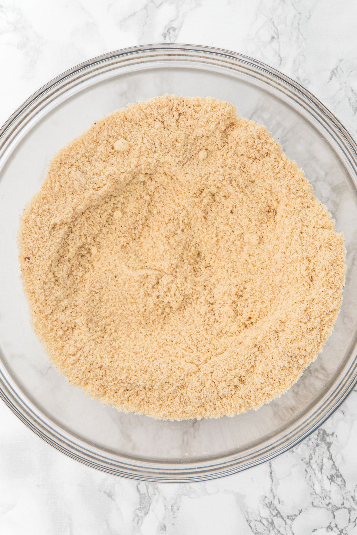 Almond flour mixture in glass mixing bowl.