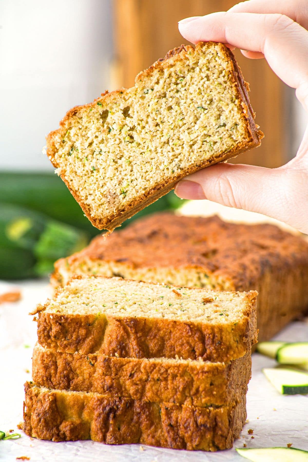 Holding up a slice of zucchini bread with almond flour