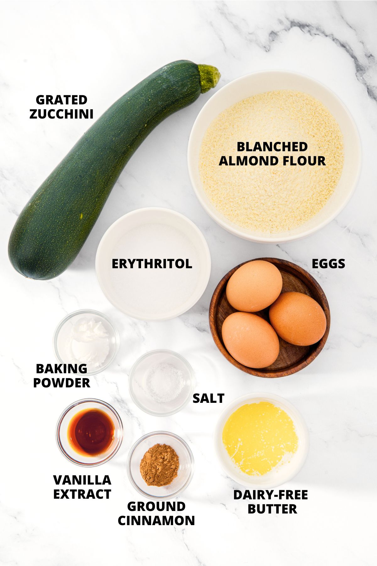 Ingredients for almond flour zucchini bread recipe laid out on marble board.