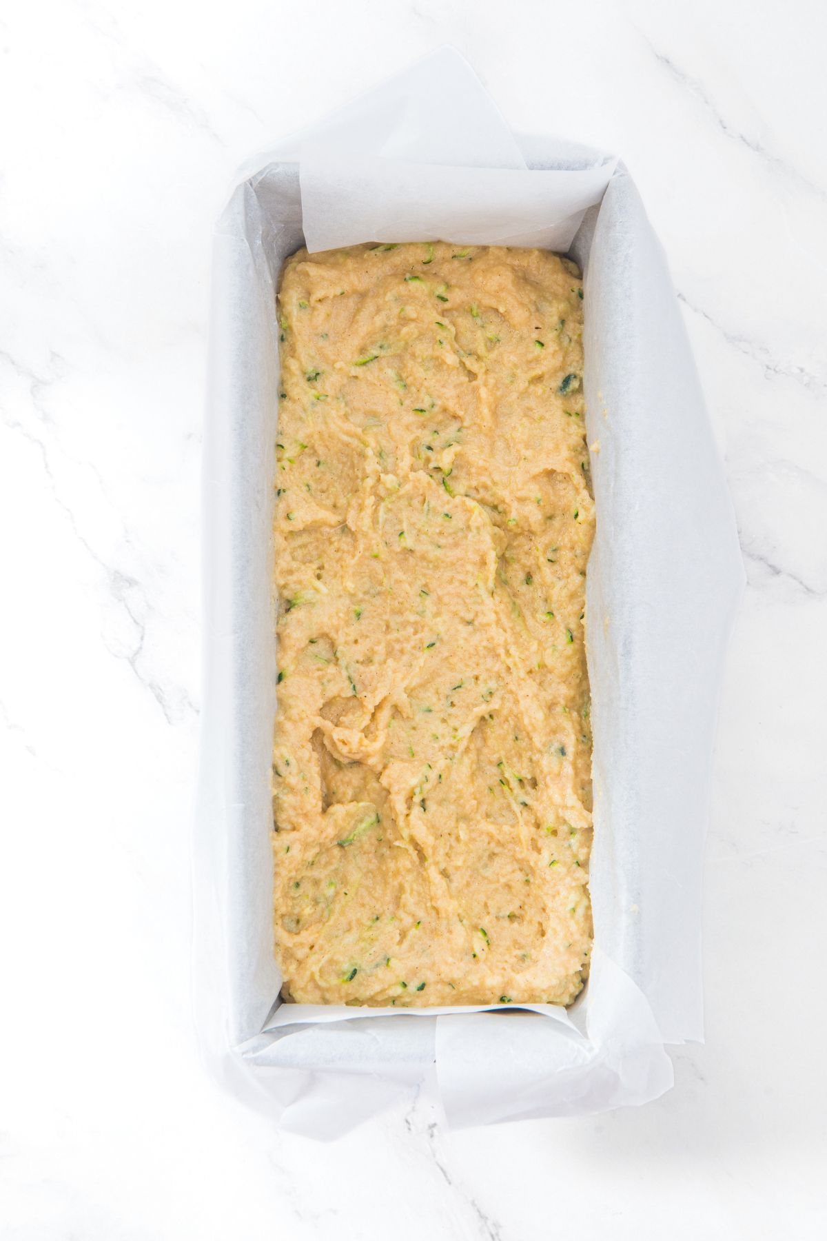 Zucchini bread batter in parchment-lined loaf pan