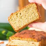 Hand holding up a slice of healthy zucchini bread with almond flour