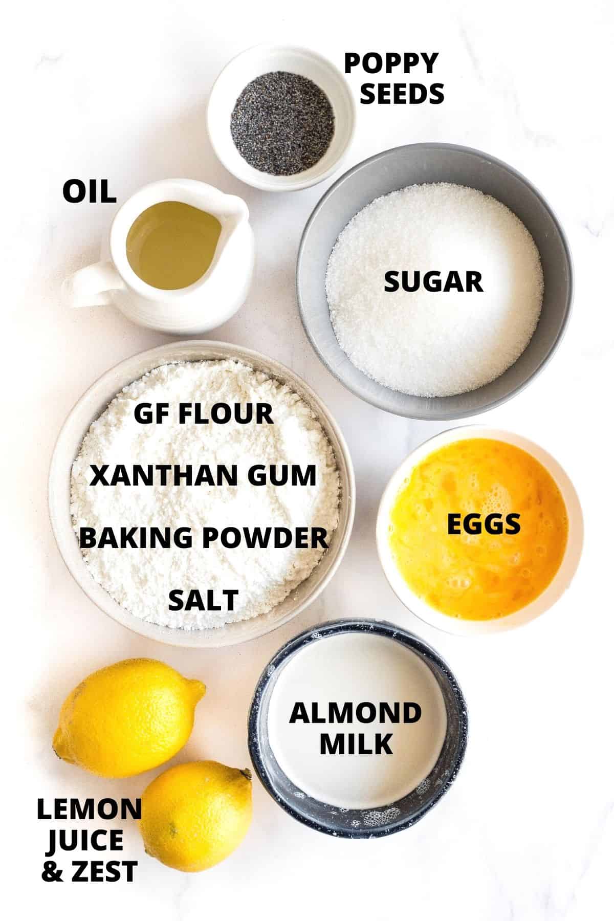 Labeled ingredients for gluten-free lemon poppy seed bread recipe on marble board.