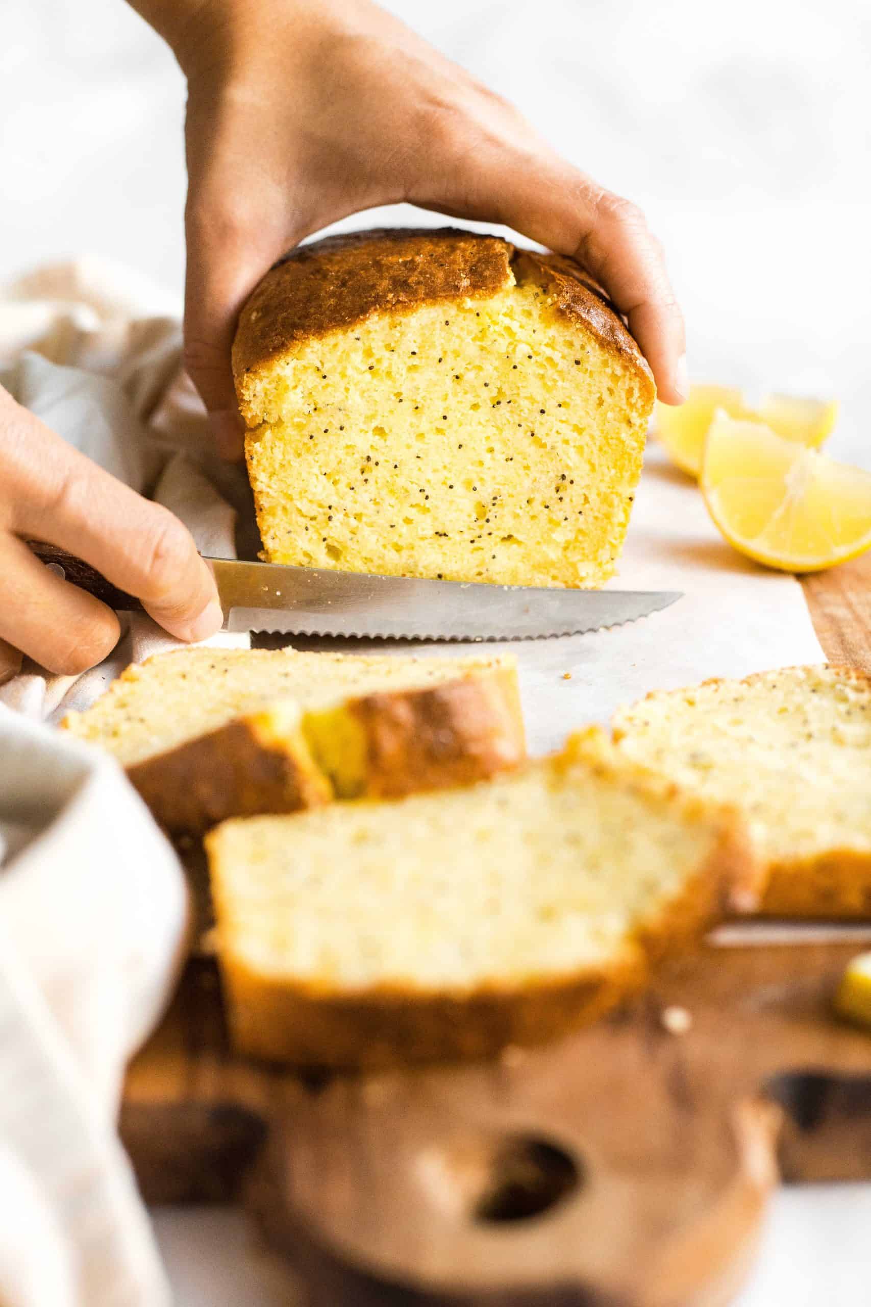 Slicing into a loaf of gluten-free lemon poppyseed bread.