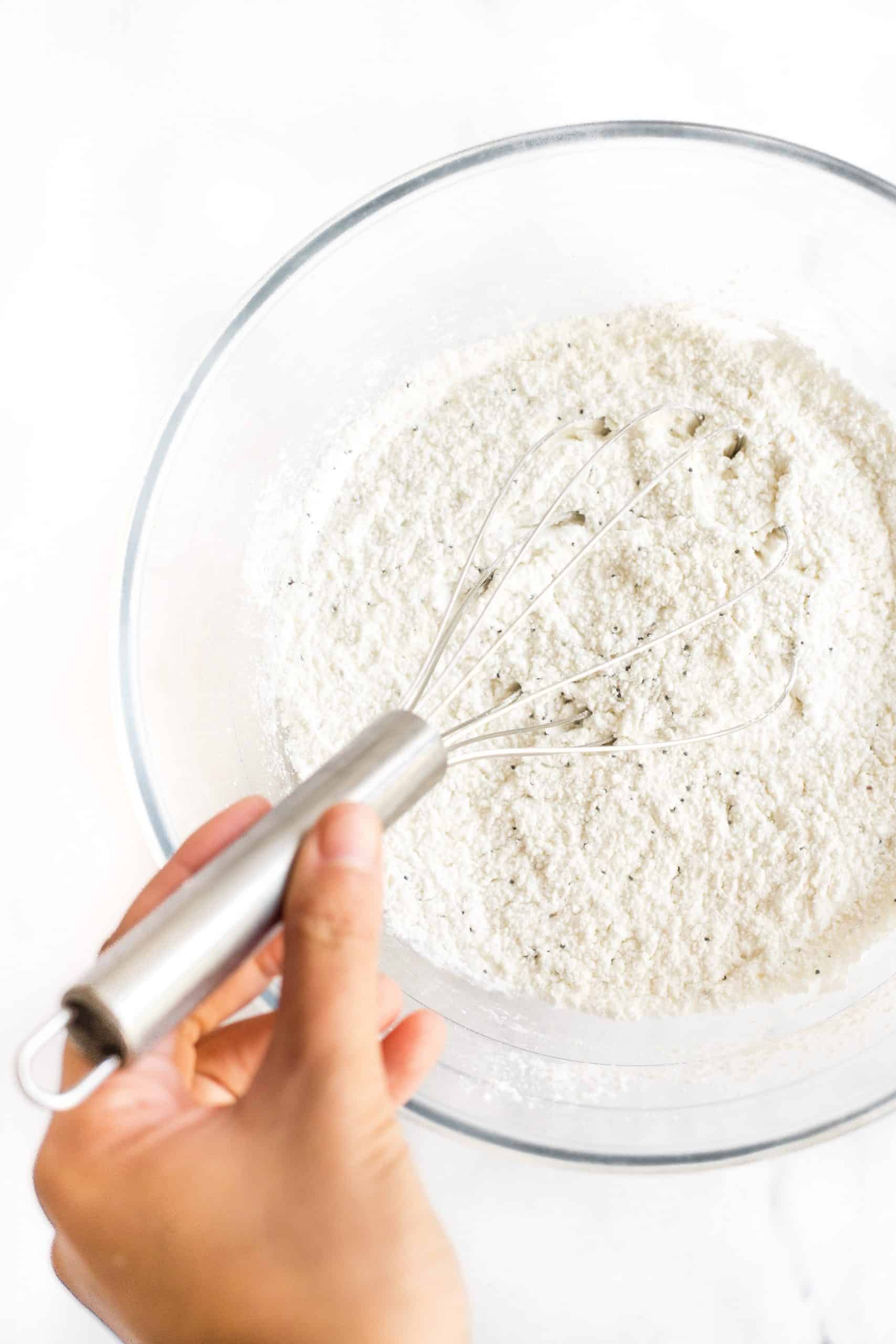 Whisking dry ingredients together in a bowl.