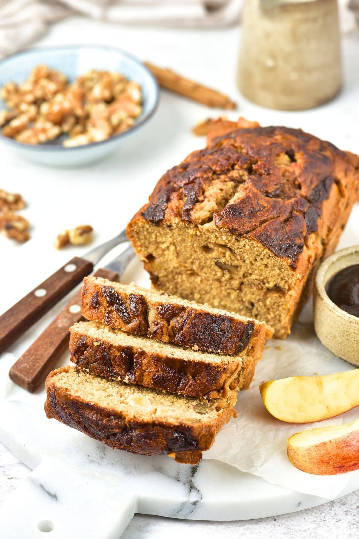 Sliced loaf of apple butter bread on marble board.