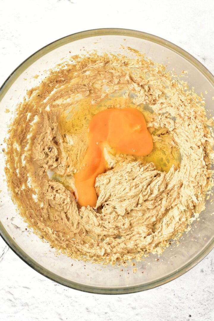 Eggs on top of light brown batter in bowl.