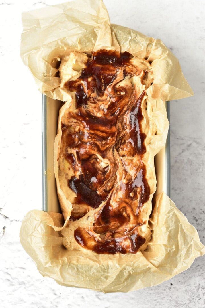 Swirled batter in parchment-lined loaf pan.