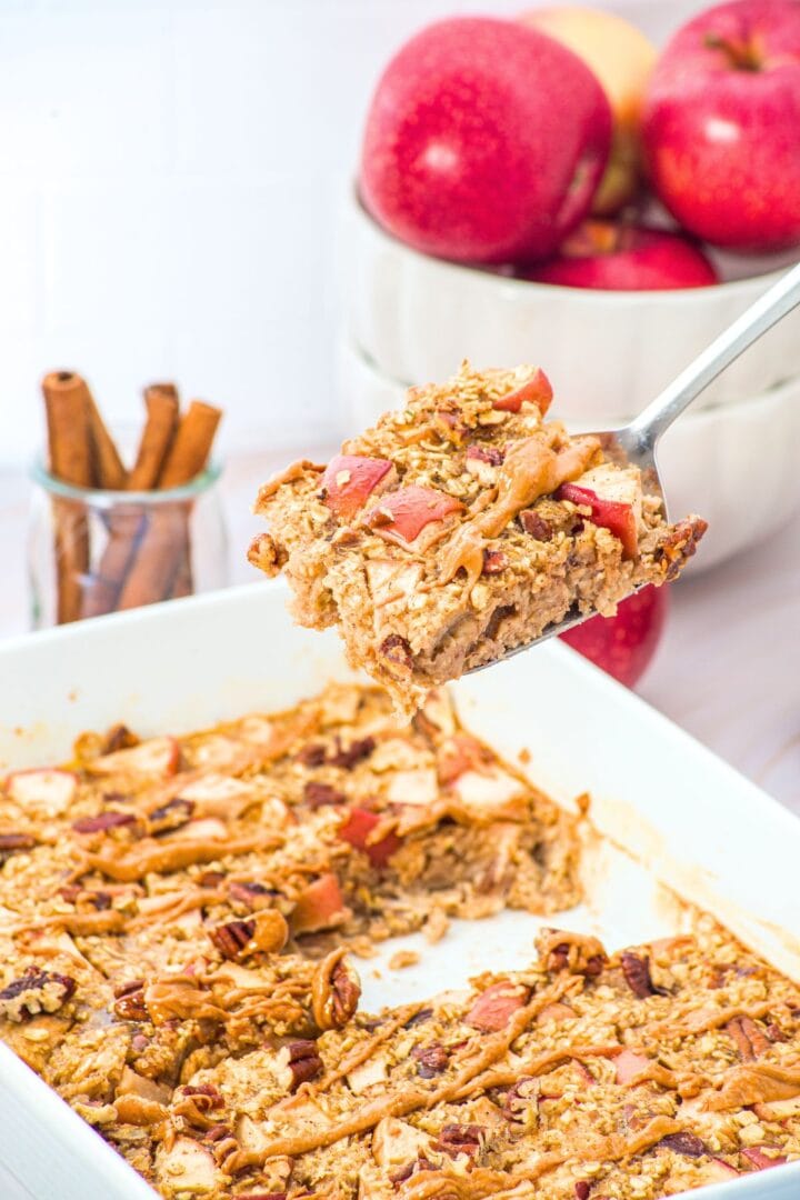 Holding up a square of apple baked oatmeal from casserole dish