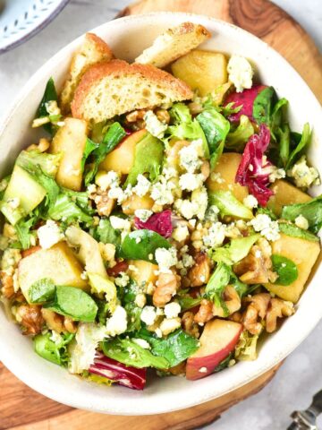 Top down view of a bowl of apple walnut salad with blue cheese