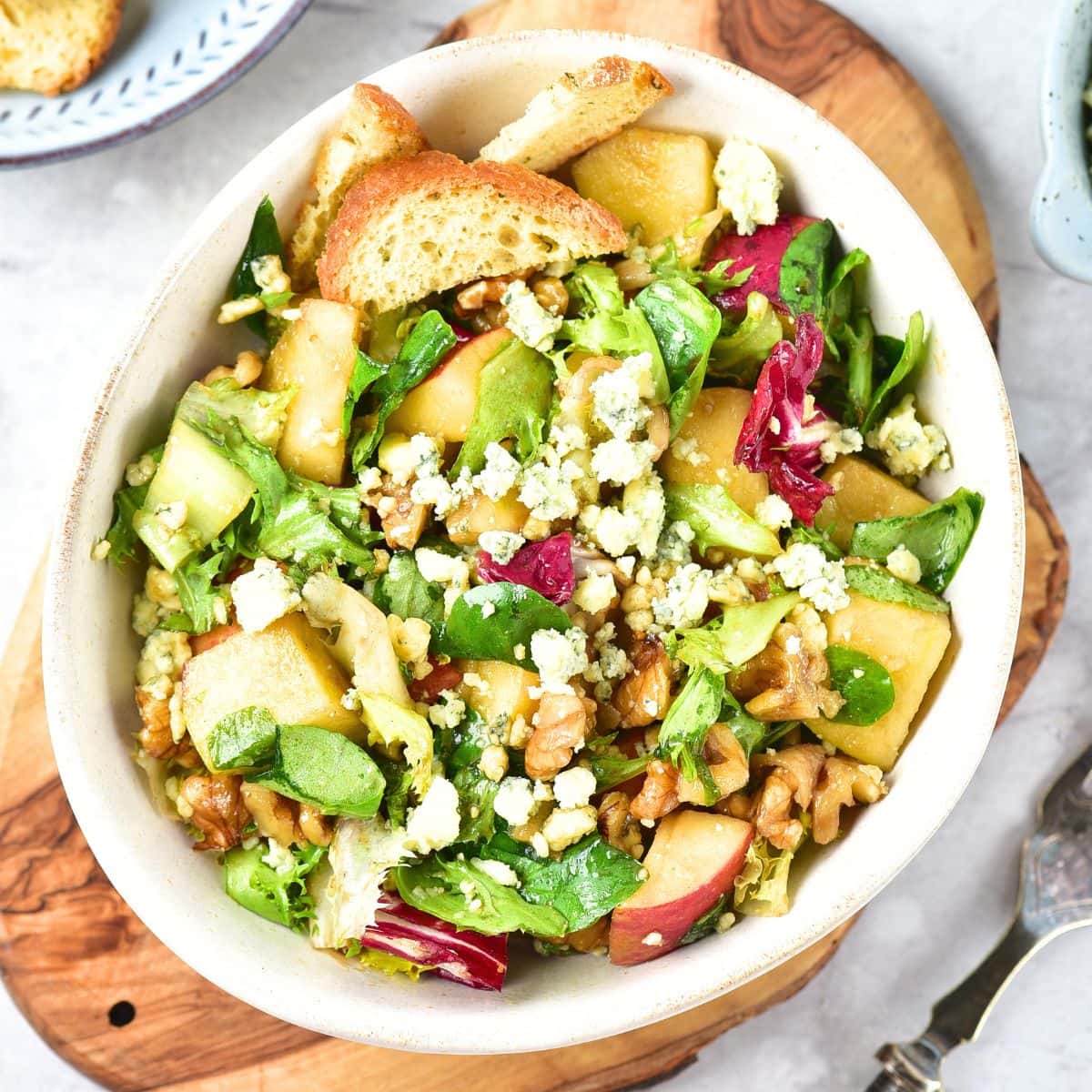 Top down view of a bowl of apple walnut salad with blue cheese