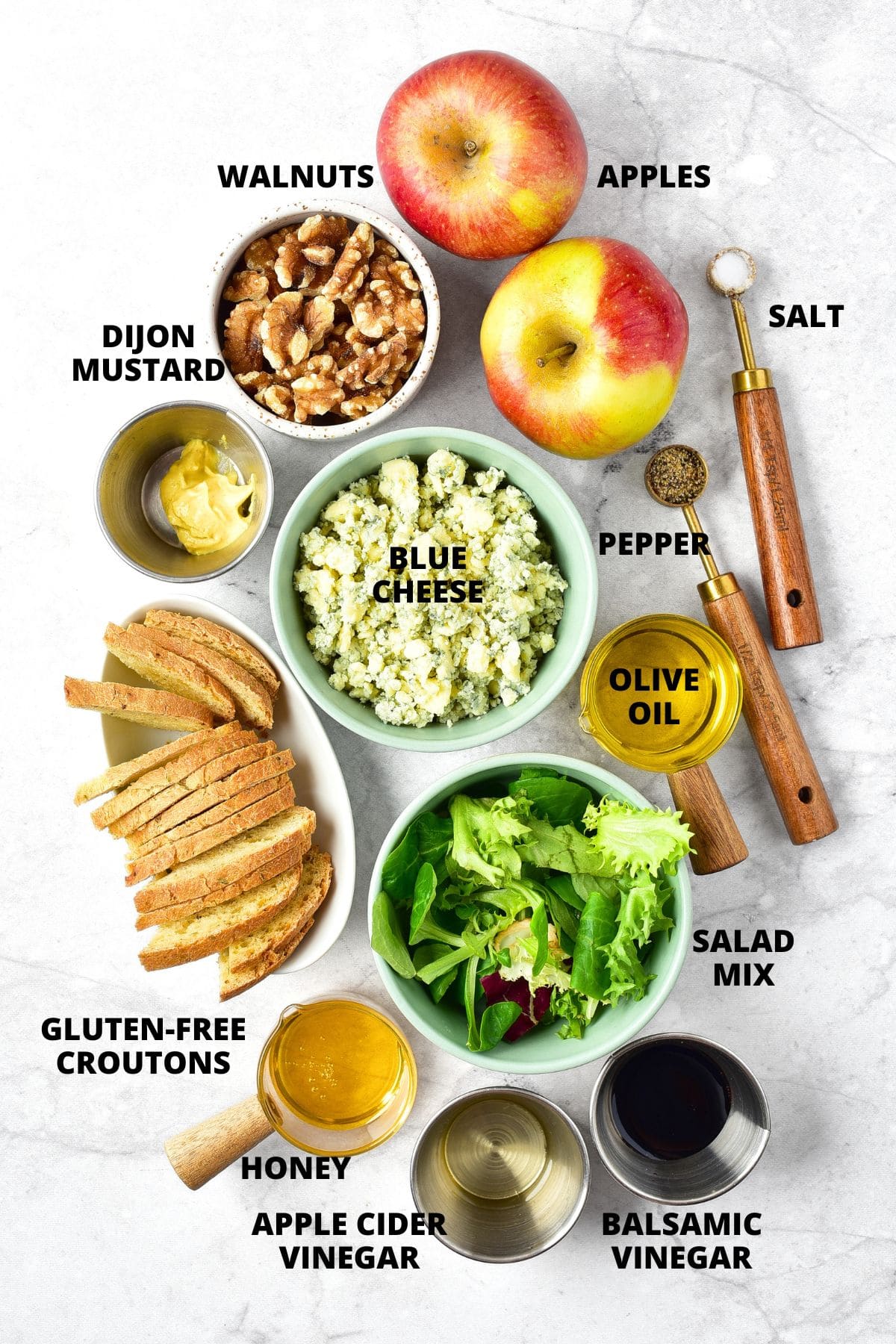 Ingredients for apple walnut salad with blue cheese recipe laid out on marble board.