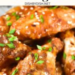 Up close view of chicken wings sprinkled with chopped green onions.