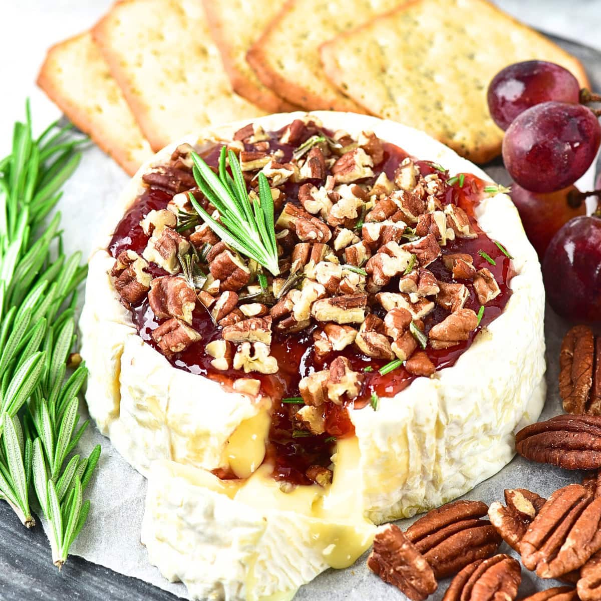 Up close view of half-eaten baked brie with jam.