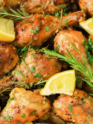 Baked chicken legs topped with rosemary and lemon