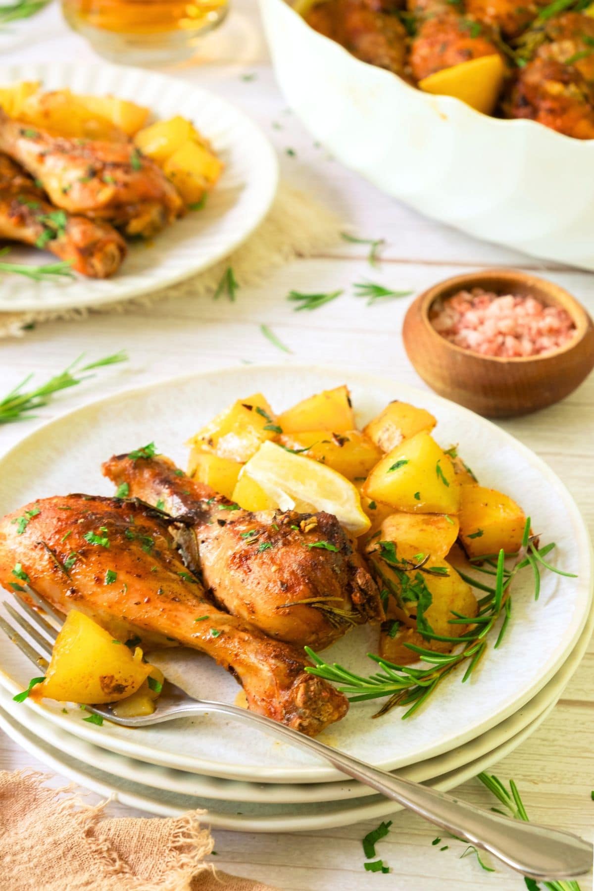 A plate of roasted chicken drumsticks and potatoes