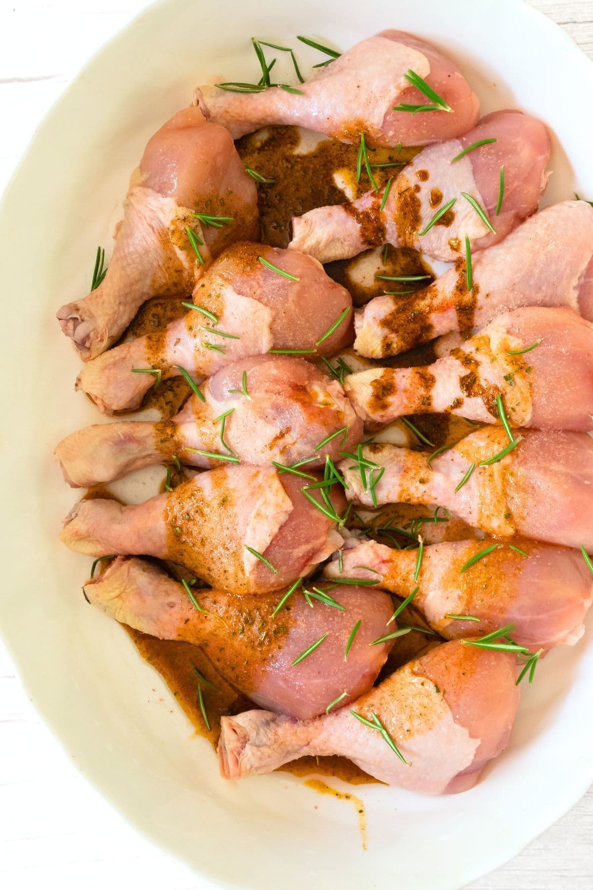 Seasoned chicken drumsticks in baking dish