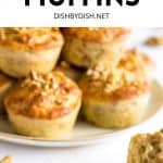 Half eaten muffin with a plate of muffins in the background.