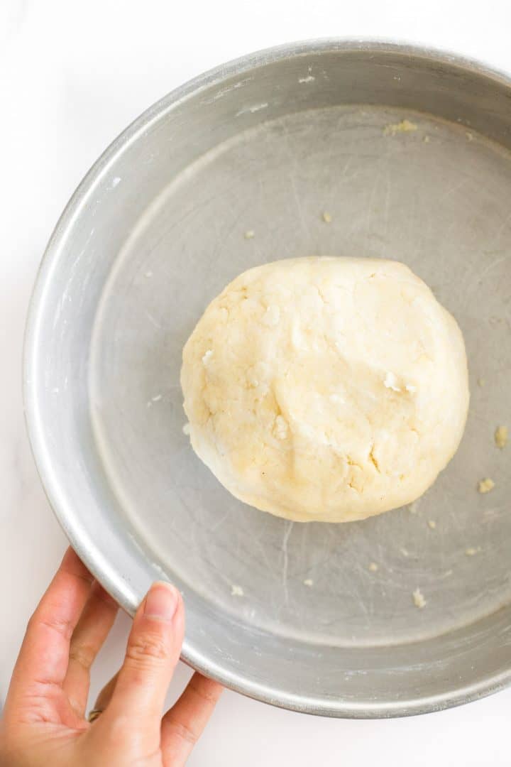 A ball of gluten-free dairy-free pie crust dough in a metal bowl