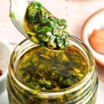 Holding up a spoonful of fresh basil chimichurri.