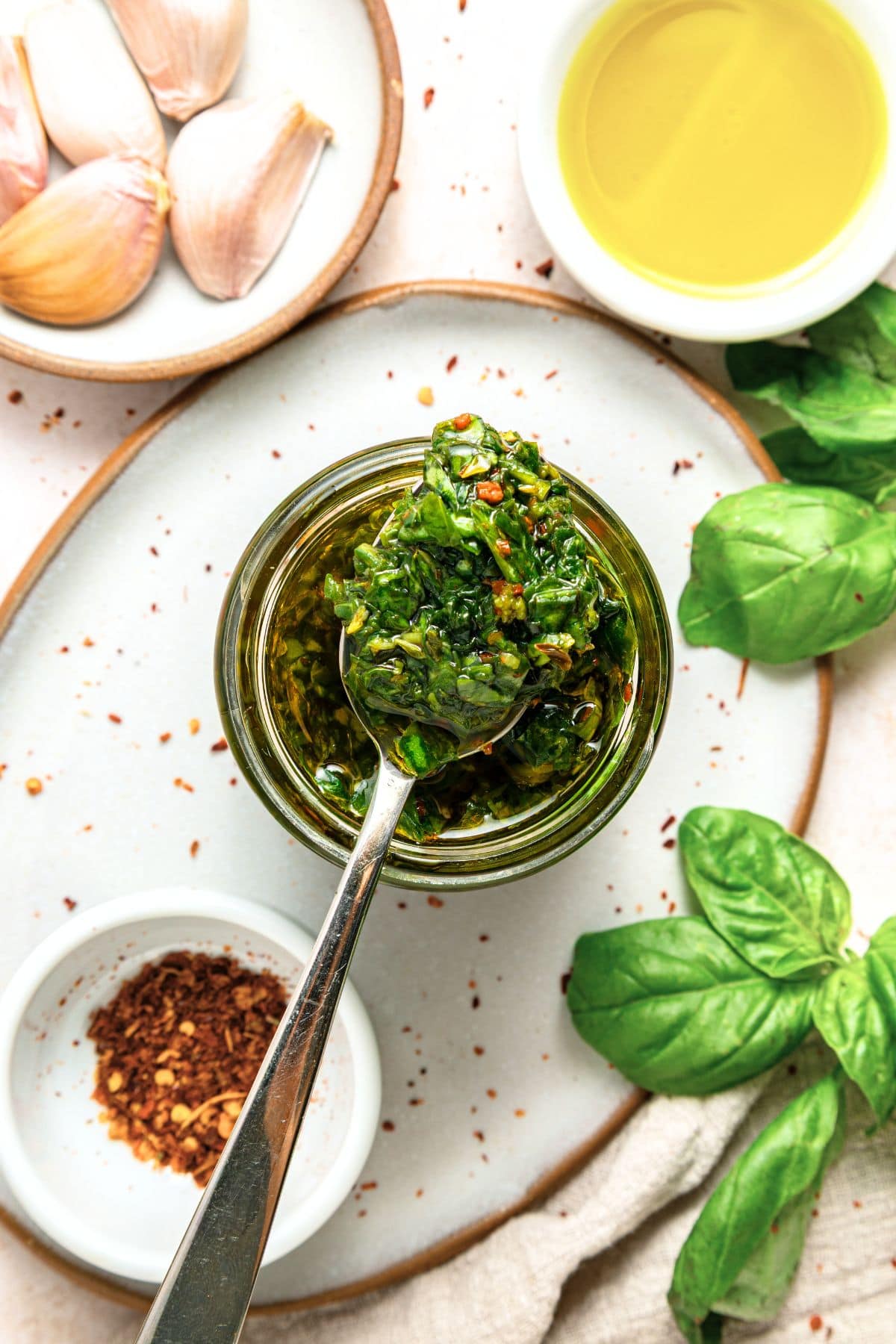 Holding up a spoonful of homemade chimichurri sauce with basil