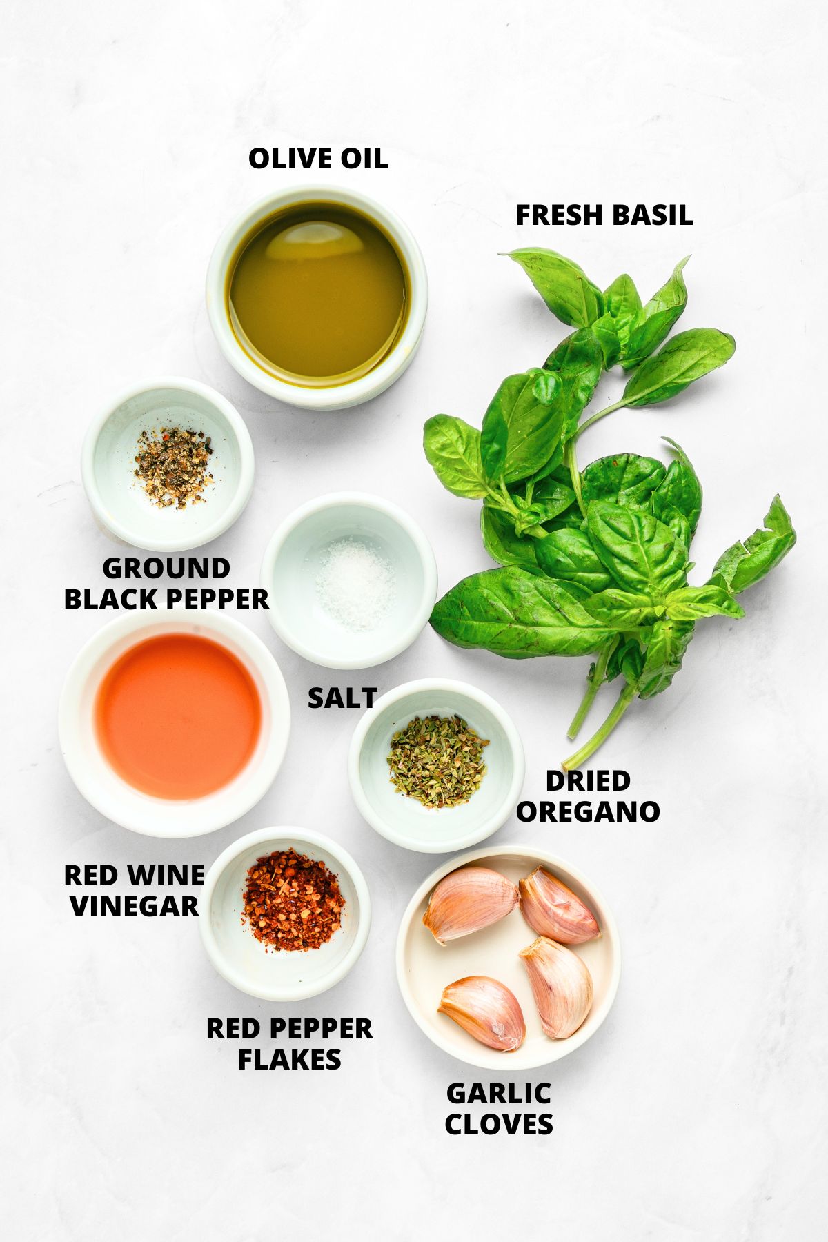 Ingredients for basil chimichurri sauce recipe laid out on white board.
