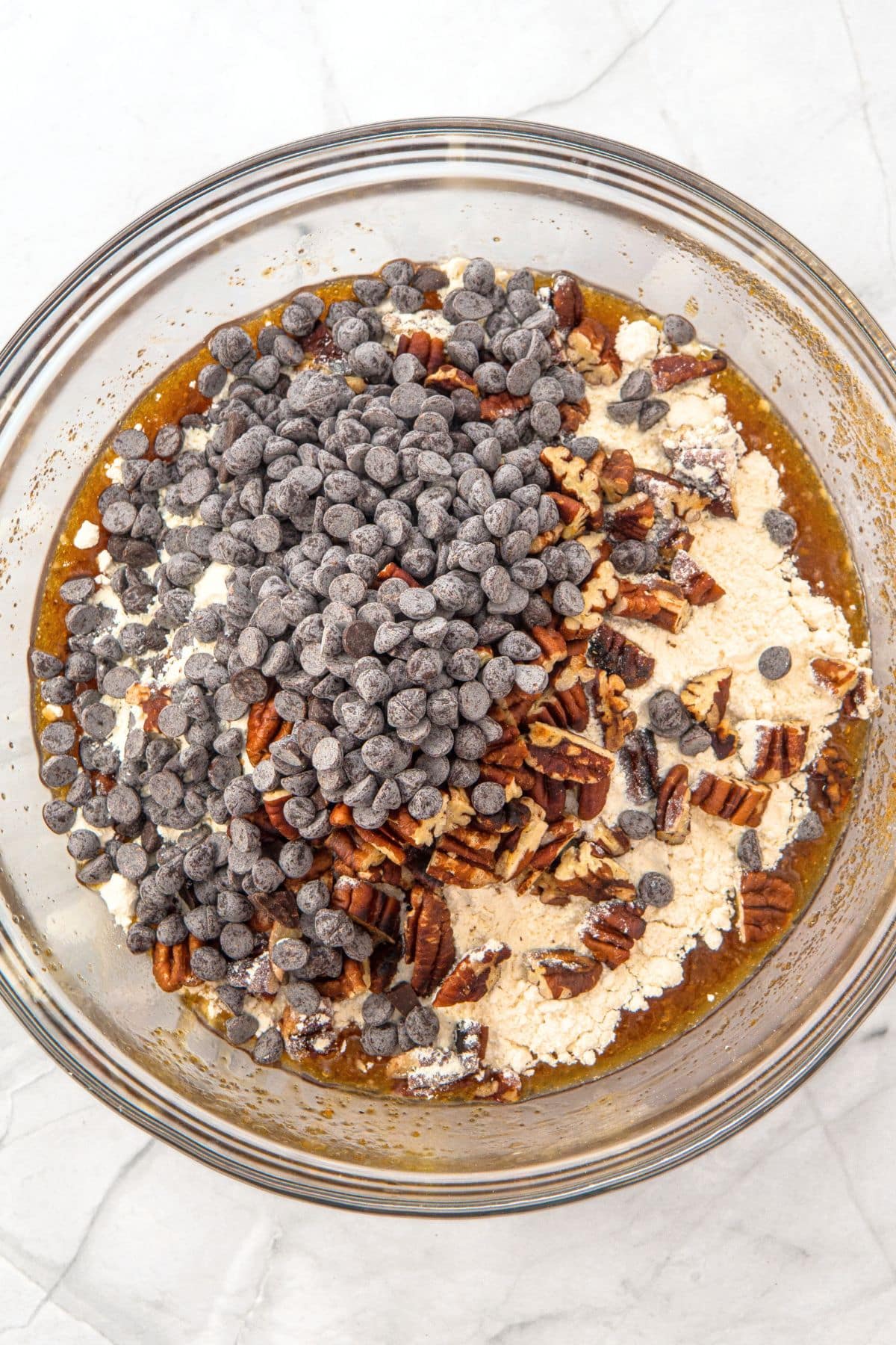 Chocolate chips and chopped pecans on top of flour mixture