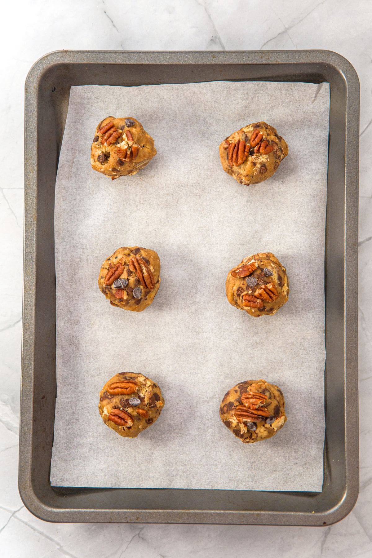 Cookie dough balls on parchment-lined baking sheet