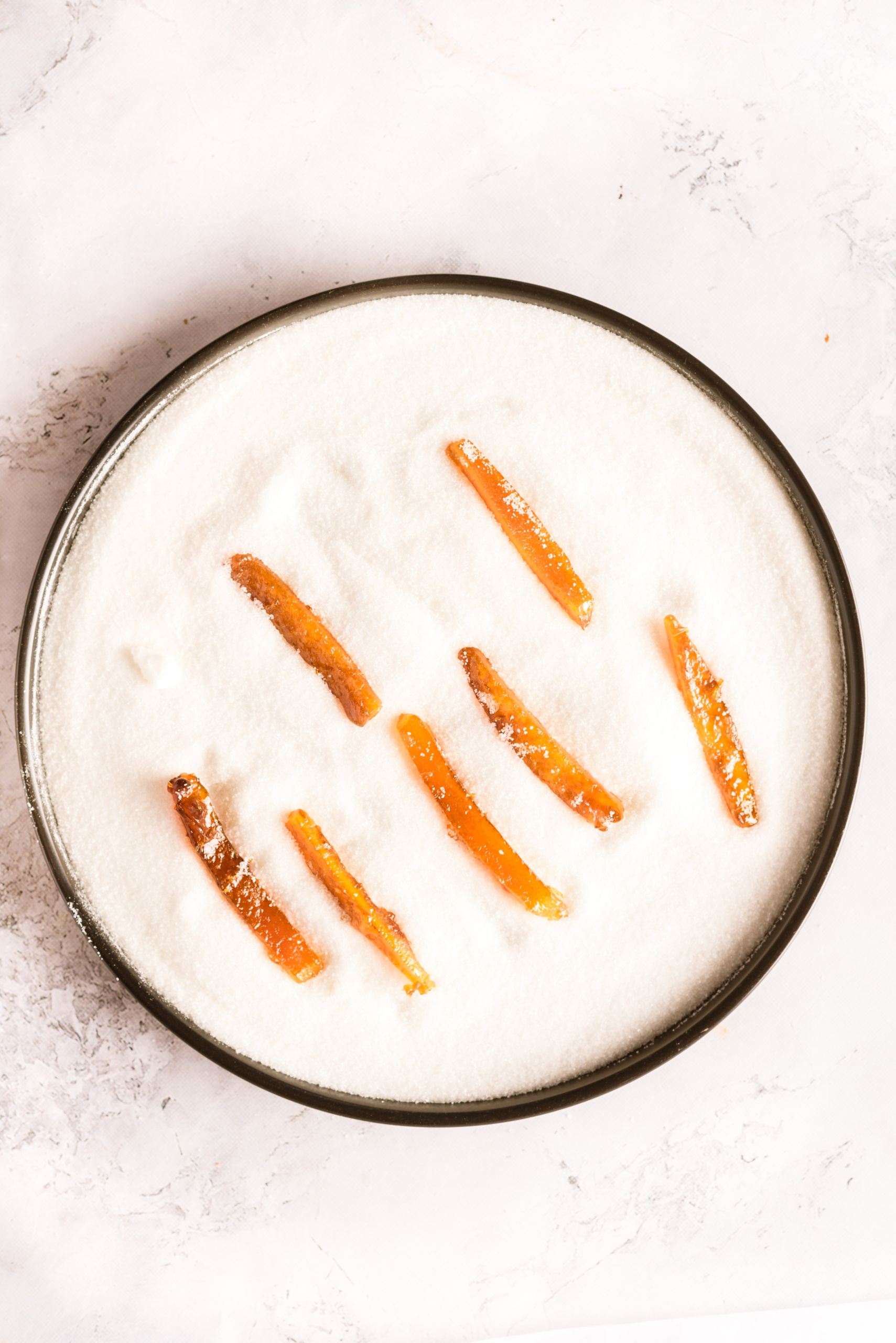 Orange peels being coated in sugar.