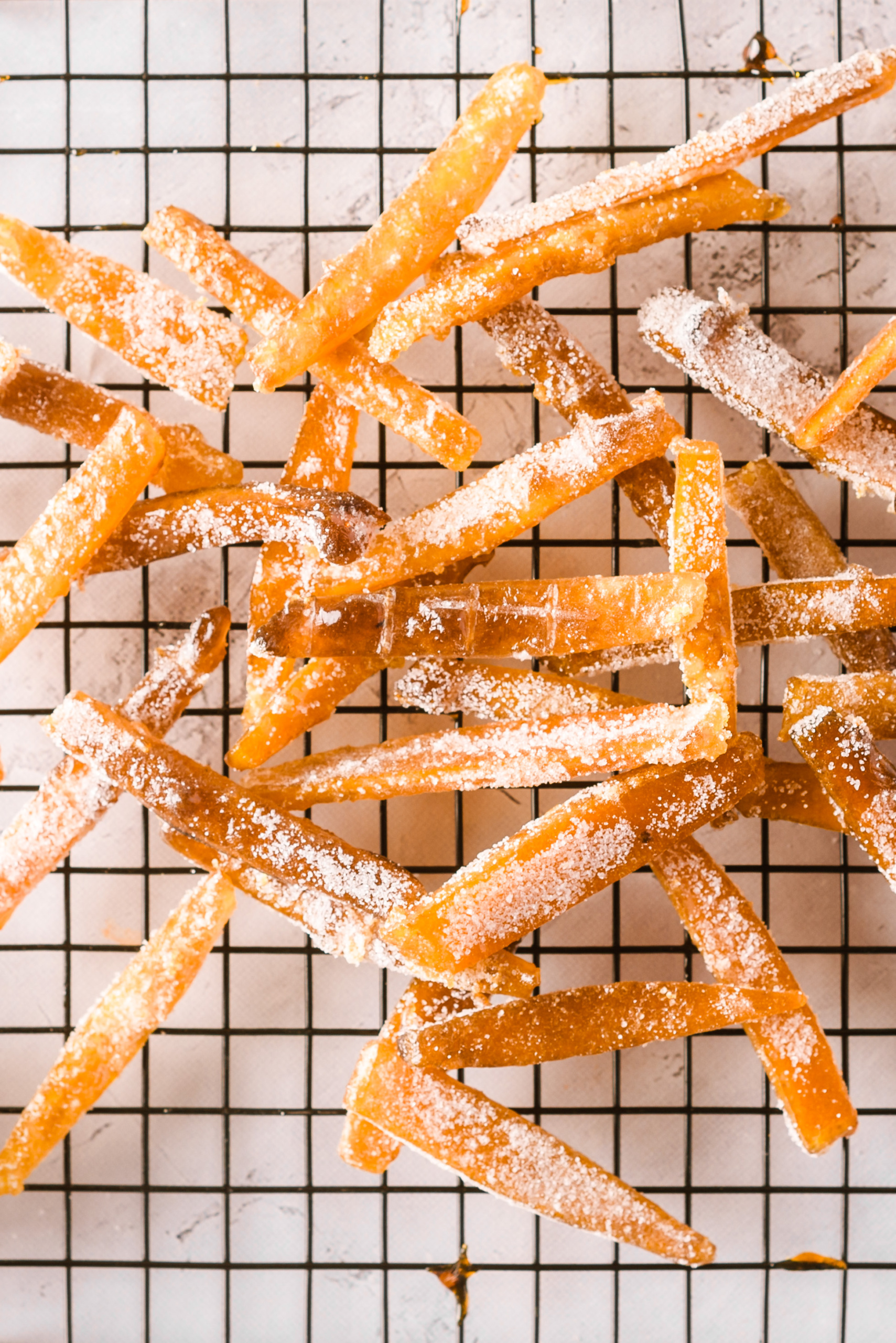 Candied orange peels drying and cooling on a wire rack.