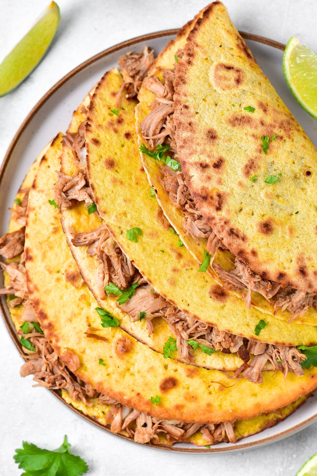 Top down view of pork carnitas tacos on plate.