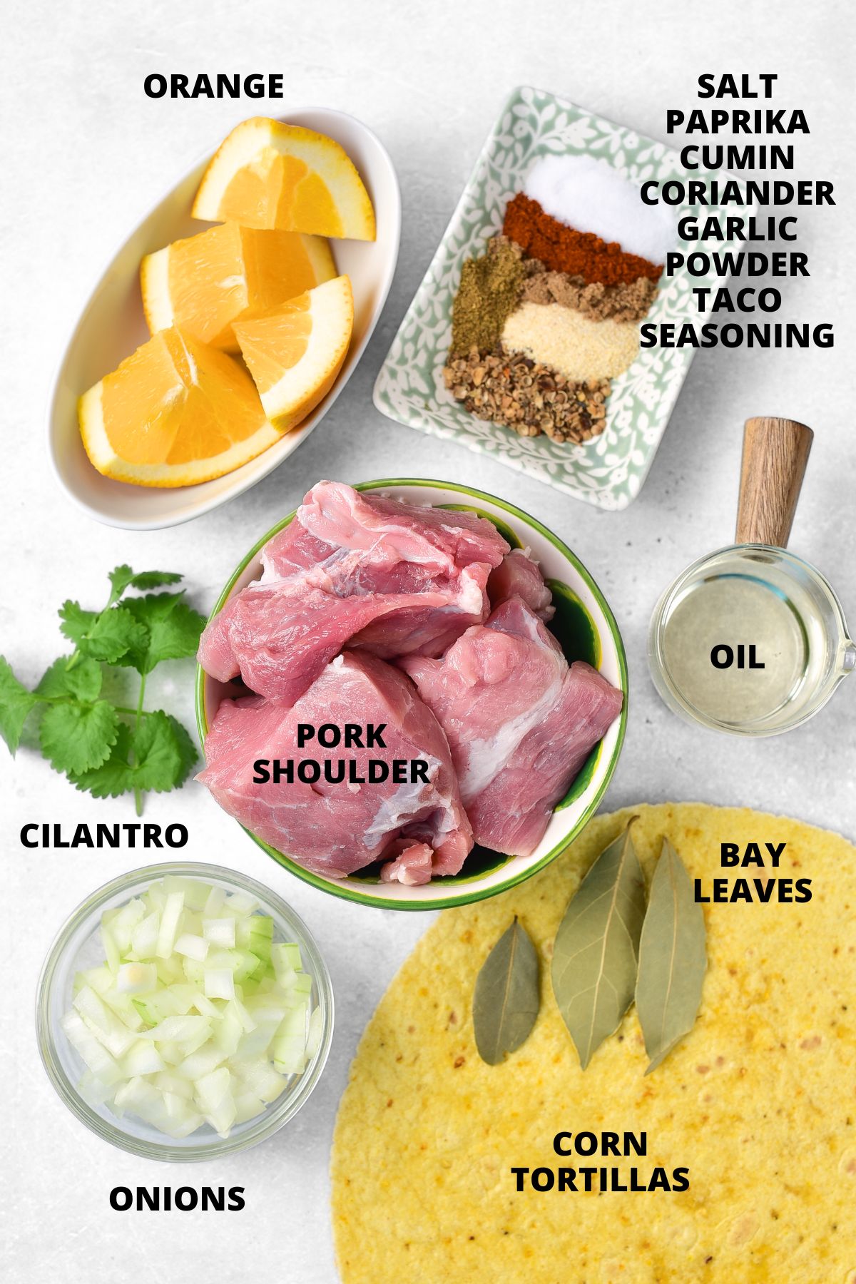 Ingredients for carnitas tacos recipe laid out on marble board.