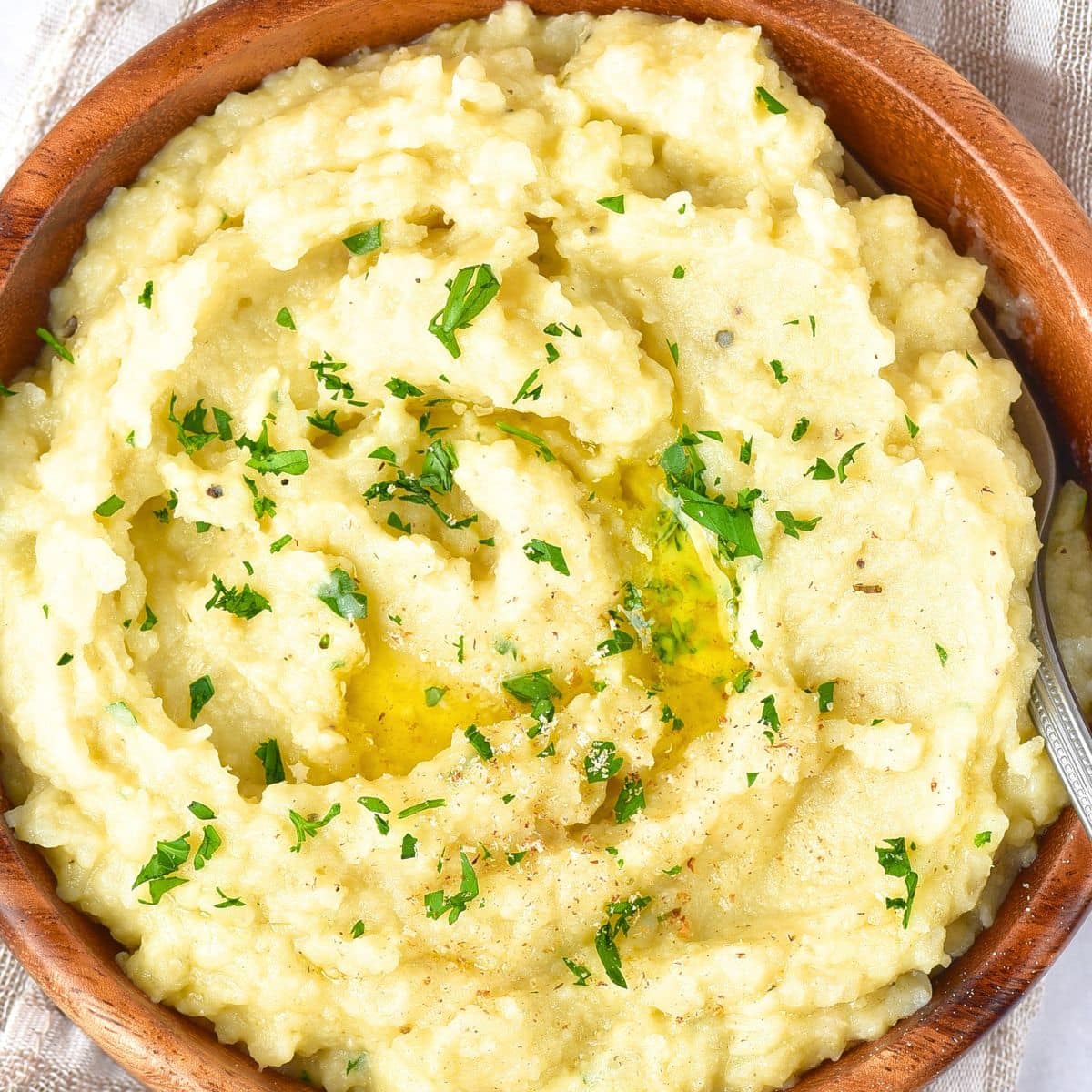 Top down view of mashed potatoes topped with chopped parsley