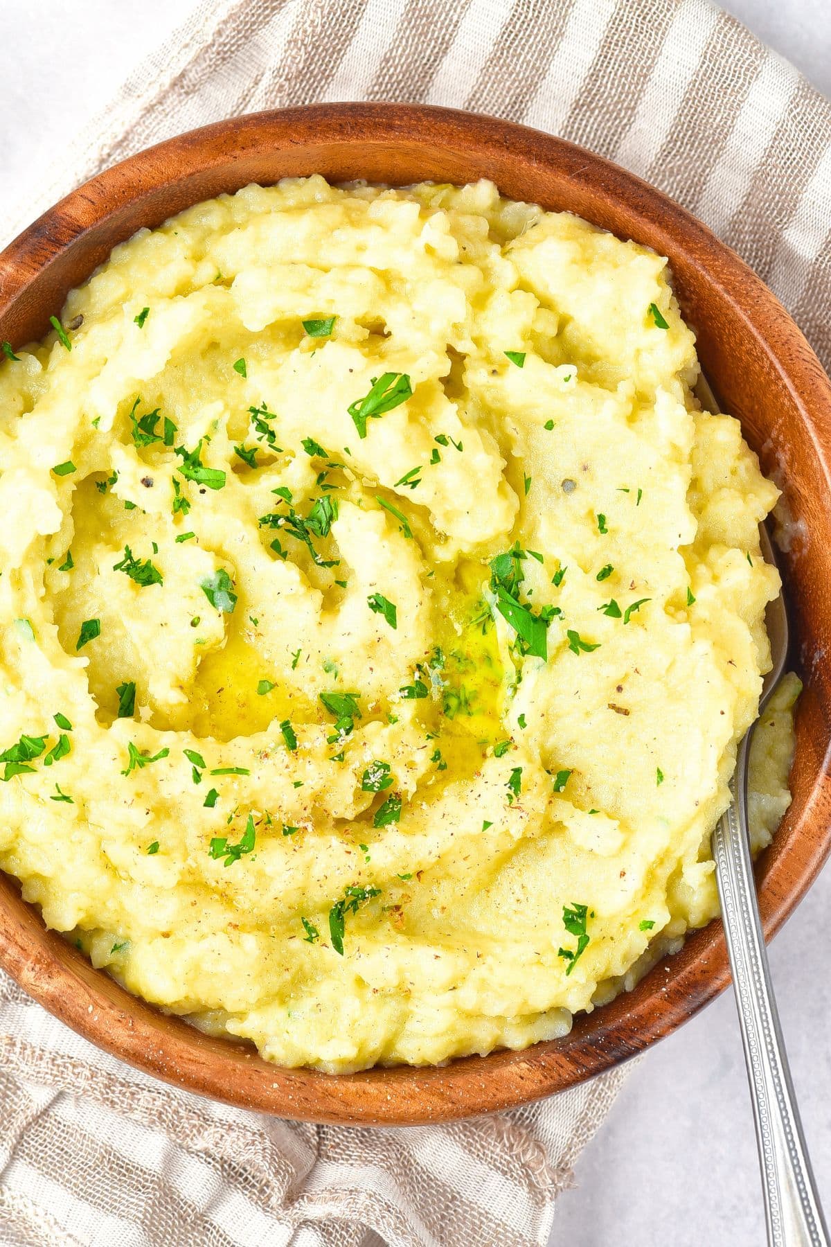 A bowl of potato cauliflower mash sprinkled with chopped parsley