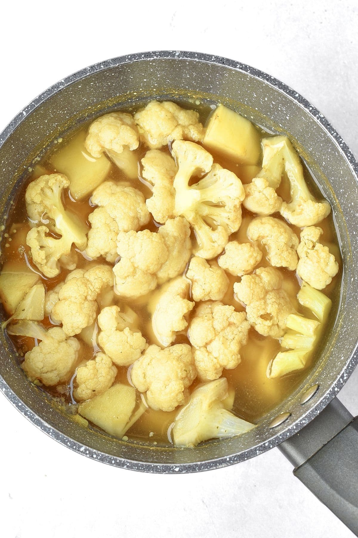 Cooked cauliflower and potatoes in stock