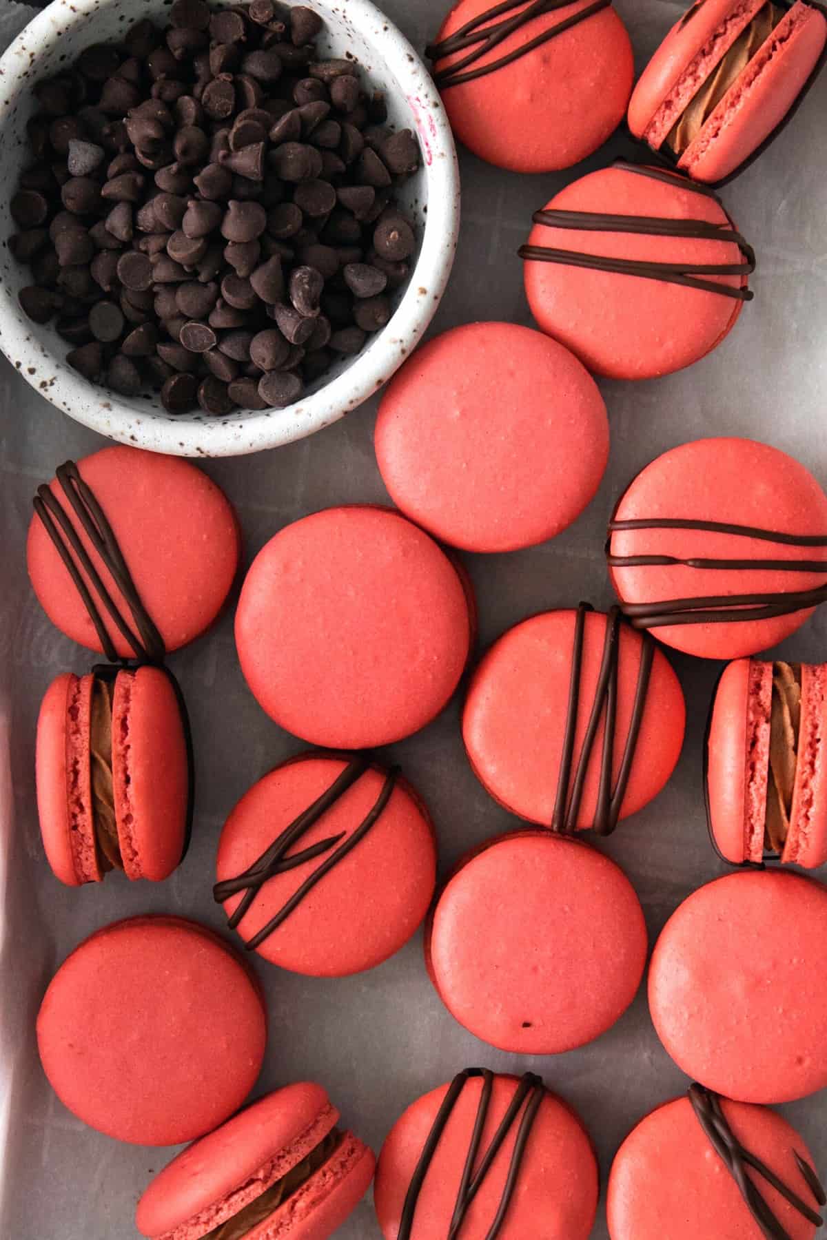 Up close shot of cherry chocolate macarons on parchment paper.