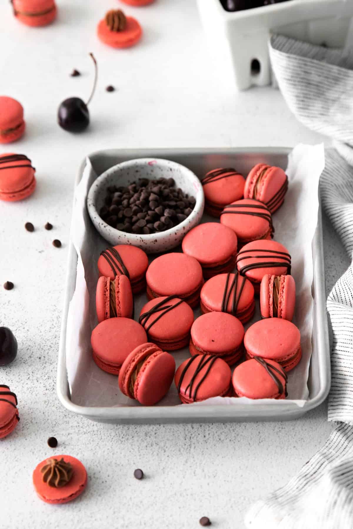 Cherry chocolate macarons on a parchment-lined baking tray.