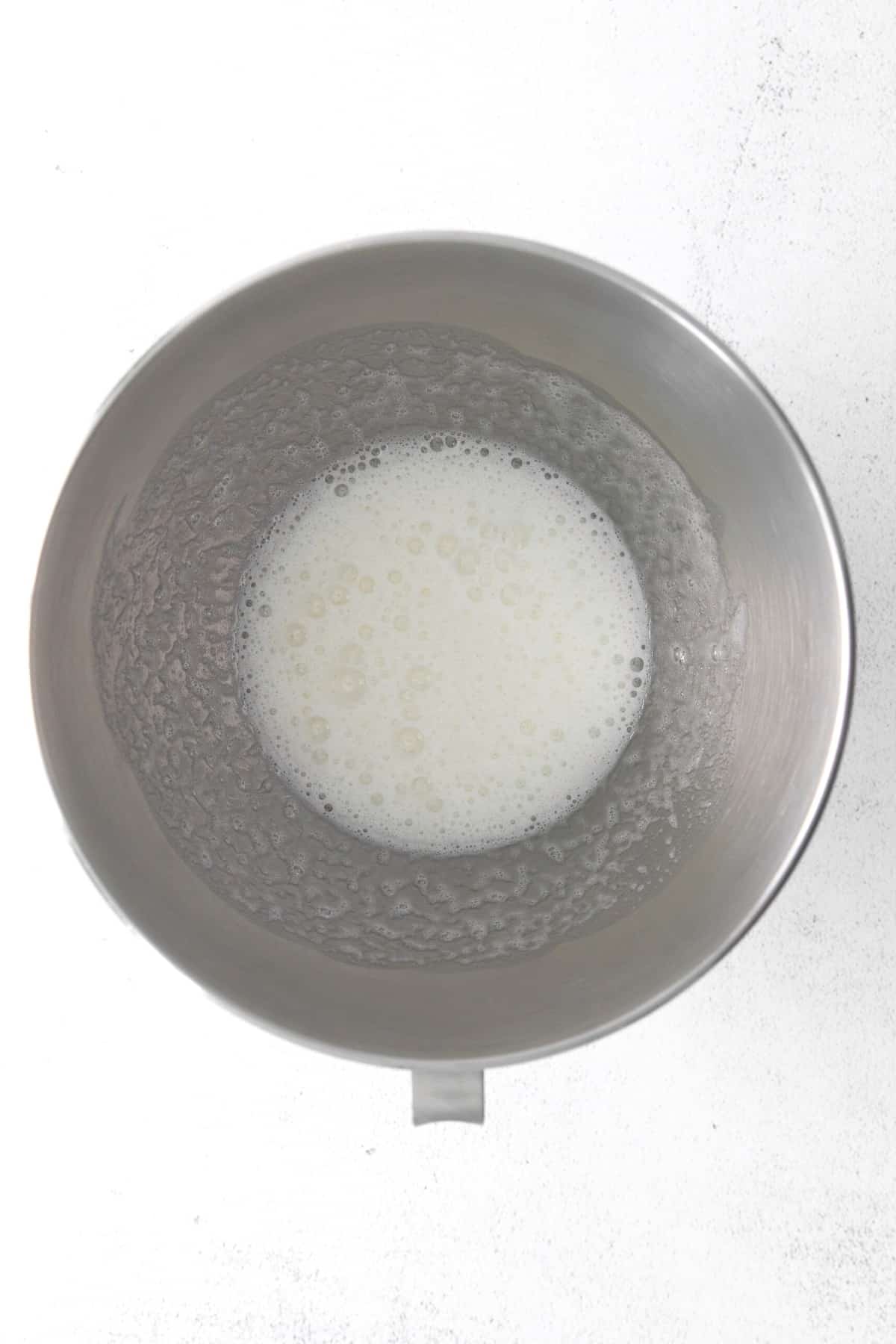 Frothy white liquid in a large mixing bowl.